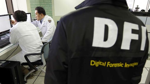 Investigation: South Korean computer researchers, left, check the shutdown computer serves of Korean Broadcasting System (KBS).