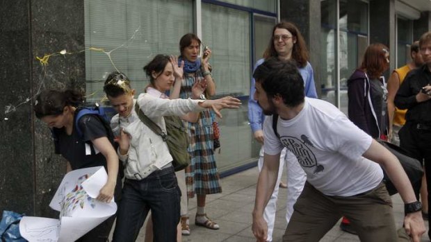 Protest: An Orthodox believer (right) throws an egg at gay rights activists in Moscow.