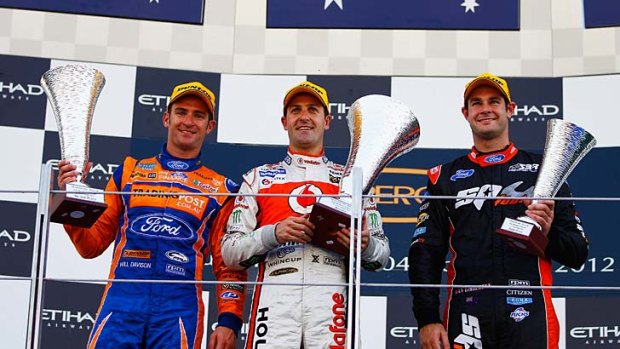 Jamie Whincup (centre) with second-placed Will Davison (left) and third-placed Shane Van Gisbergen on the podium in Abu Dhabi.