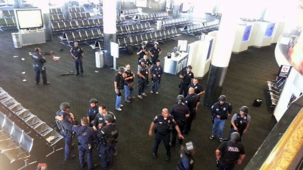 Lockdown: Police stand near the location of an unidentified weapon in terminal three of LAX airport.