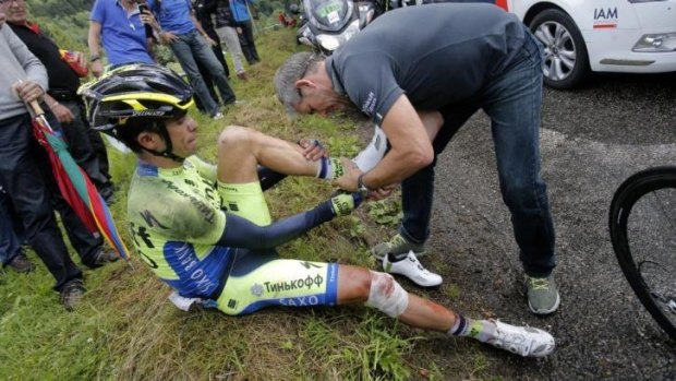 Battered and bruised: Spain's Alberto Contador receives treatment shortly before retiring from the Tour de France.