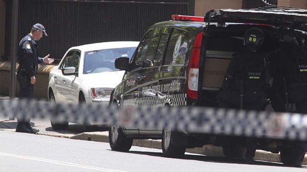 A police officer speaks to the driver of a car that stopped outside NSW Parliament House, sparking a bomb scare.