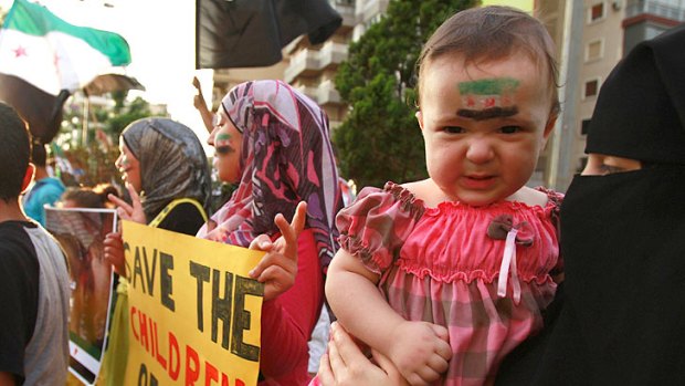 A child with a Syrian opposition flag painted on the face takes part in a protest in Tripoli, northern Lebanon, against an attack by Syrian President Bashar al-Assad's forces on the Syrian city of Houla.