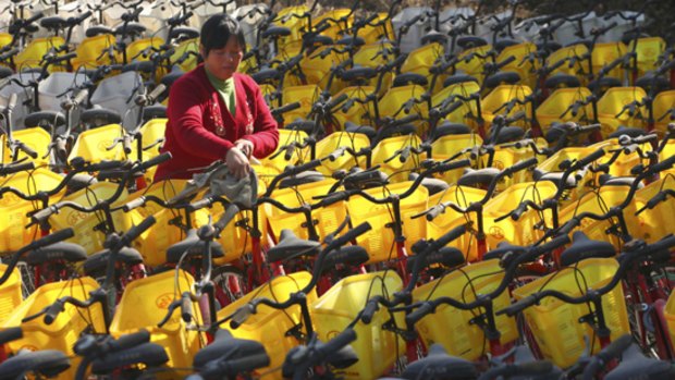 A migrant worker cleans bicycles at a rental station in Beijing.