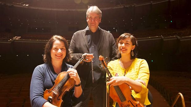Conductor Brett Kelly with two members of the Impossible Orchestra, Deborah Goodall (left) and Rebecca Adler.