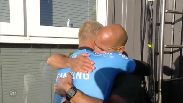 Mick Fanning and Kelly Slater hug after Fanning's close encounter with a shark. 