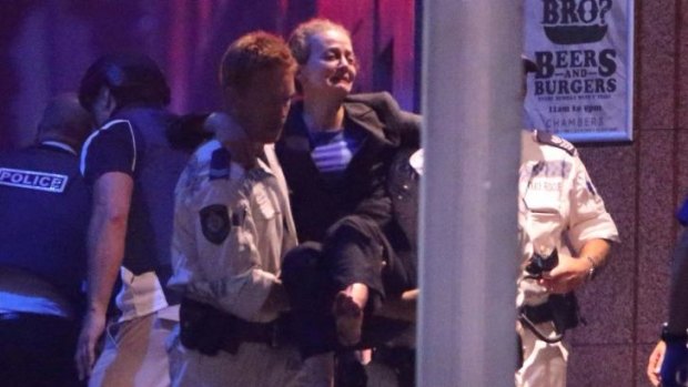 Hostage Marcia Mikhael is assisted from the Lindt Cafe in Martin Place.