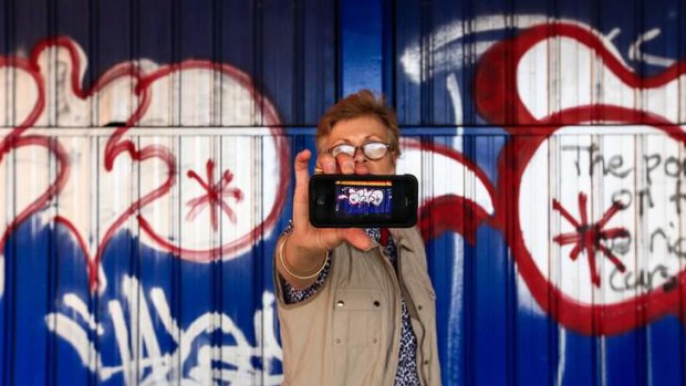 CEO of CBD limited Jane Easthope takes a photo of graffiti using the new iPhone app vandal trak which aims to help stop vandalism graffiti around Canberra.