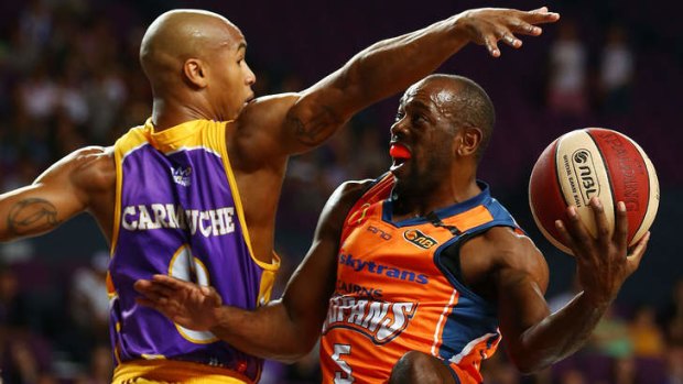 Charles Carmouche of the Kings defends against Jamar Wilson of the Taipans.