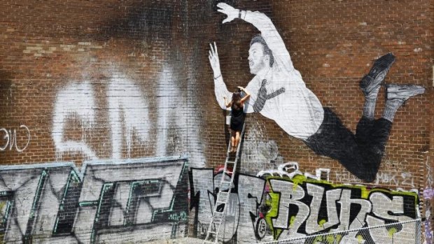 Street artist Baby Guerilla works on a new large-scale stencil work in South Melbourne.