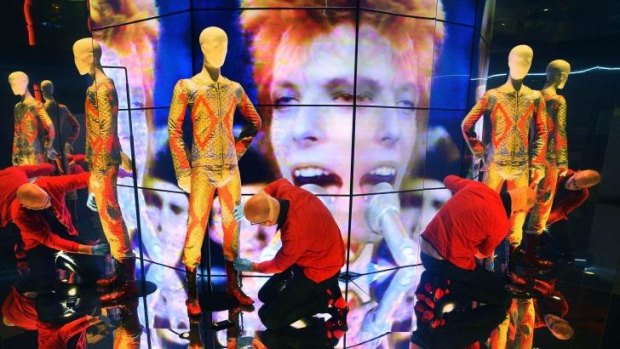 David Bowie exhibition co-ordinator Daniel Slater fixes the pants of a Bowie costume at ACMI.