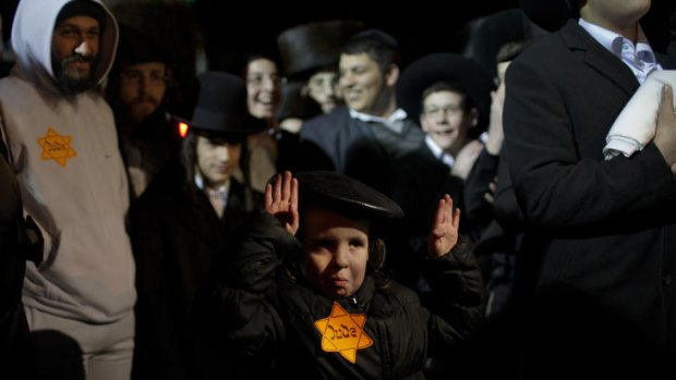 A child raises his hands in imitation of a famous picture from the Holocaust in Jerusalem's Mea Shearim enclave during a protest by ultra-Orthodox Jews.