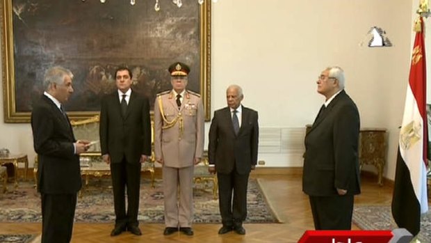 Egypt's interim President Adly Mansour, right, swearing in Ahmed Galal, left, as finance minister in Cairo.