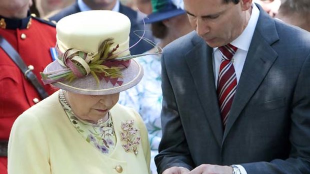 Britain's Queen Elizabeth looks at a gift, a handheld Blackberry device, at Research in Motion.