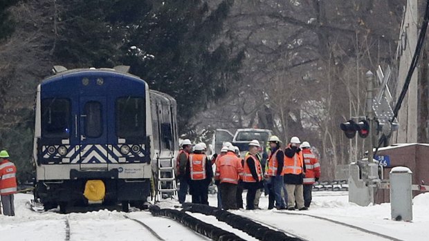 Officials examine the railroad crossing and the back of a Metro-North Railroad commuter train on Wednesday in Valhalla, New York.  