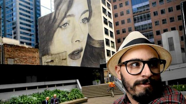 Street artist Rone with his work on a Collins Street building.