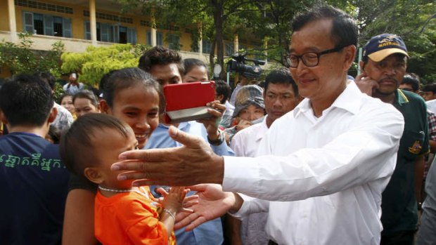 Long fight: Sam Rainsy visits a polling station in Phnom Penh on Sunday.