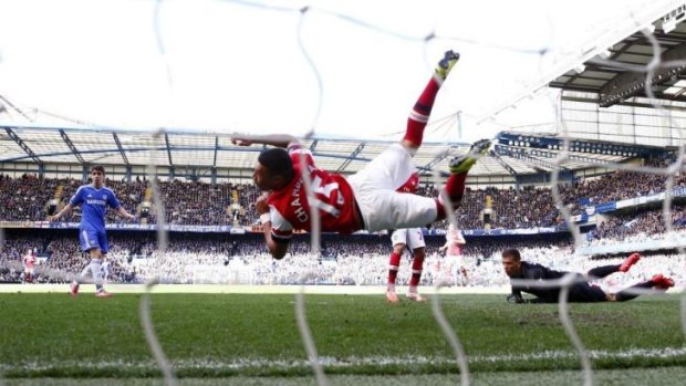 What was he thinking: Arsenal outfielder Alex Oxlade-Chamberlain dives to save a shot on goal by Chelsea with his hand.