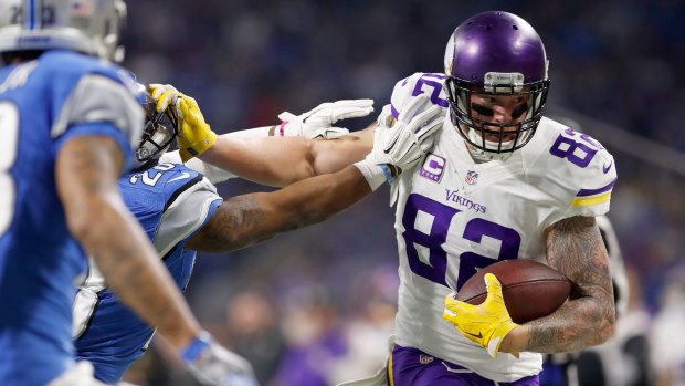 Stiffarm: Kyle Rudolph of the Vikings pushes away from a defender.