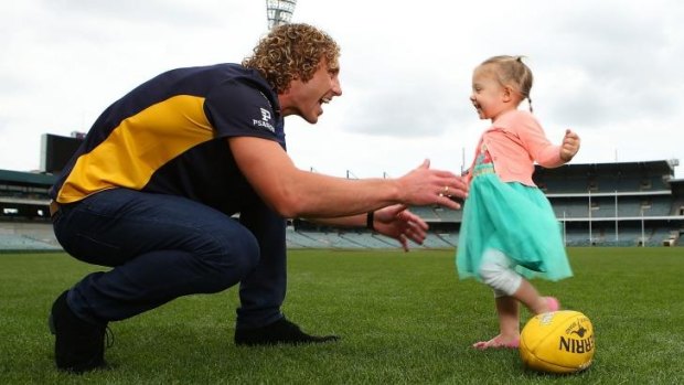 Matt Priddis plays with his daughter, Nala, following a press conference at Patersons Stadium on Tuesday.