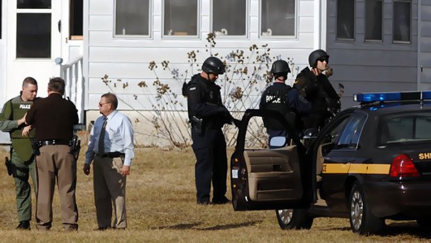 Armed police outside a Virginia home after the discovery of eight bodies set off a massive manhunt.
