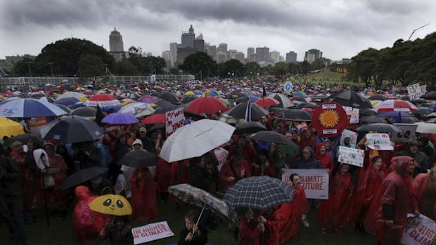 Rain won't halt their parade: Activists in Sydney braved thunderstorms on Sunday to demand action over climate change.