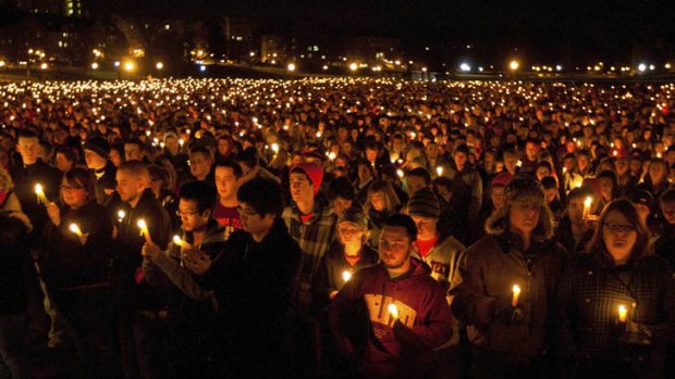 Students hold candles during a memorial service and candlelight vigil for fallen police officer Deriek W. Crouse on the campus of Virginia Tech.