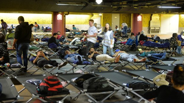 Refugees rest in a parking garage in the main rail station in Salzburg, Austria on Sunday