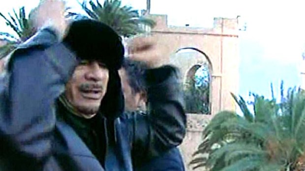 A screen grab taken from Libyan state television shows Libyan leader Moamer Kadhafi gesturing at supporters during an address at the Green Square in Tripoli.