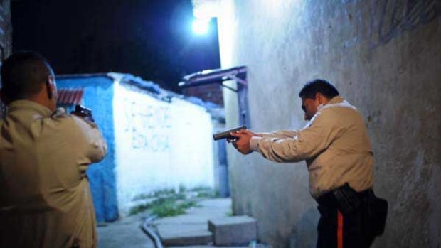 A special tactical division of the Sucre police force conduct a late night foot patrol in the Petare area of Caracas.