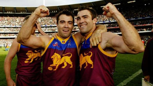 The Scott brothers, Chris and Brad, celebrate winning the 2002 Grand Final at the MCG wearing the traditional Lions guernsey.
