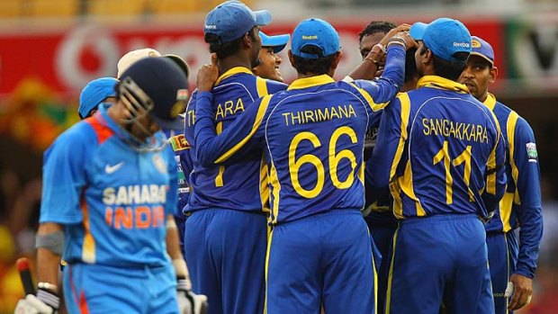 Off you go: Sri Lankan players celebrate the wicket of Indian champion Sachin Tendulkar last night.