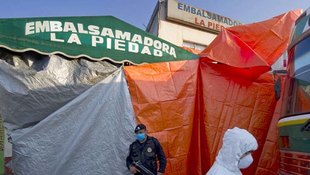 Soldiers shield an emergency morgue erected to cope with scores of  bodies from mass graves discovered in the country's north.