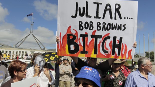 Getting personal ... protesters wave placards at the No Carbon Tax rally outside Parliament House in Canberra.