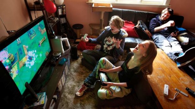 Gender balance: Kyah Horrocks plays a video game with sister Sian while friends look on.