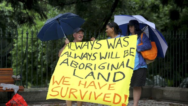 Jeff Gater from Acacia Ridge and Noritta Morseu-Diop, from Brisbane, hold up a sign as part of the Invasion Day protest on Australia Day.