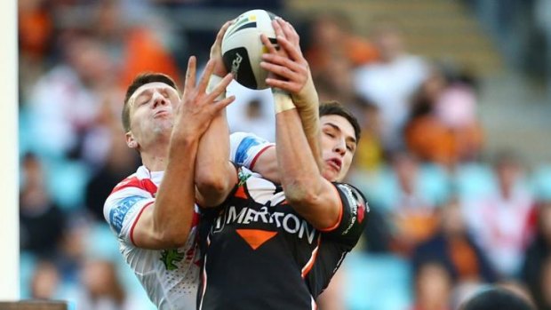 Up in the air: Gareth Widdop of the Dragons, left, and Mitchell Moses of the Tigers contest a high ball at ANZ Stadium.