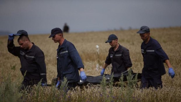 Members of the Ukrainian Emergency Ministry carry a body at the crash site of Malaysia Airlines Flight MH17 on Saturday.