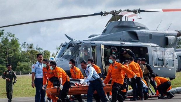 Members of Indonesian search and rescue team carry the body of a victim of the AirAsia flight QZ8501 crash at Iskandar Airbase.