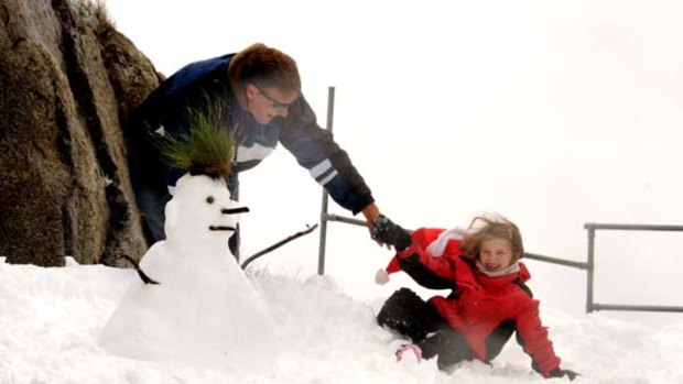 Frosty the snowman ... Wayne McQueen's daughter Jordan, 6, had her first experience of snow on the top slopes of Thredbo yesterday morning during a blizzard.