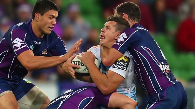 Under the pump: Gold Coast's Greg Bird is set upon by Melbourne Storm players on Saturday night.