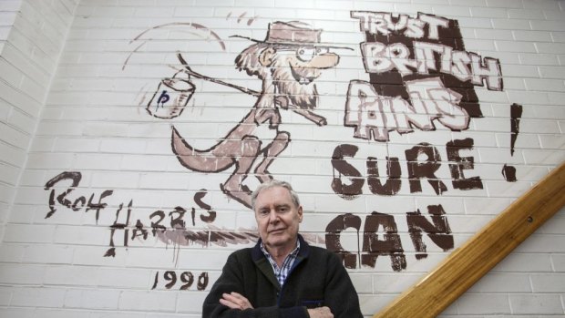 Owner of  Penhalluriack's Building Supplies in Caulfield, Frank, in front of a mural painted by Rolf Harris.