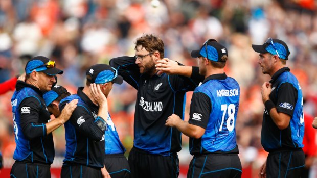Well placed: Nathan McCullum, Brendon McCullum and Daniel Vettori of New Zealand swipe away bugs during the clash against Bangladesh.