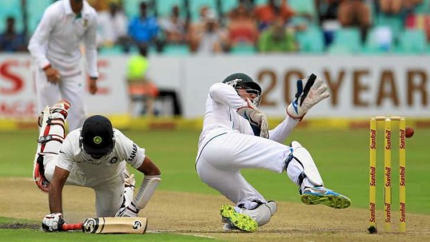 Close call: South Africa's wicketkeeper Abraham Benjamin de Villiers attempts a run out against India's batsman Cheteshwar Pujara.