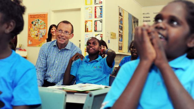 Prime Minister Tony Abbott pictured in the Far North Queensland Aboriginal community of Aurukun in 2012. The Abbott government will fund 400 truancy officers to persuade Aboriginal children to go school.
