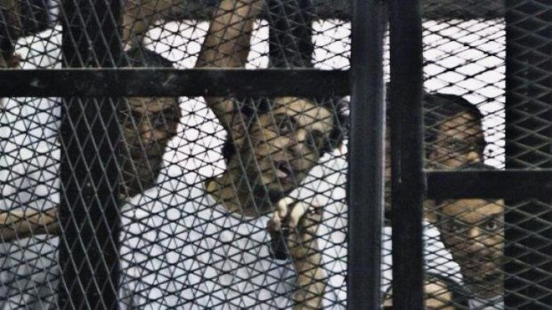 To be freed: Al-Jazeera's Egyptian journalist Abdullah Elshamy, centre, appears in a defendants' cage along with several other defendants.