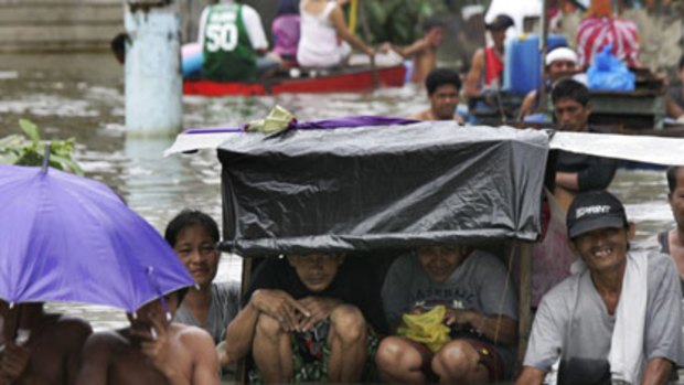 East of Manila . . . Residents make their way through flood waters while in the north of the country Typhoon Parma wrecked havoc.