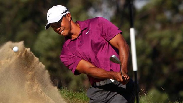 Tiger Woods plays out of the bunker on the par 3 15th hole.
