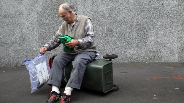 Sam Bracanov sits on a rubbish bin outside the Auckland District Court.