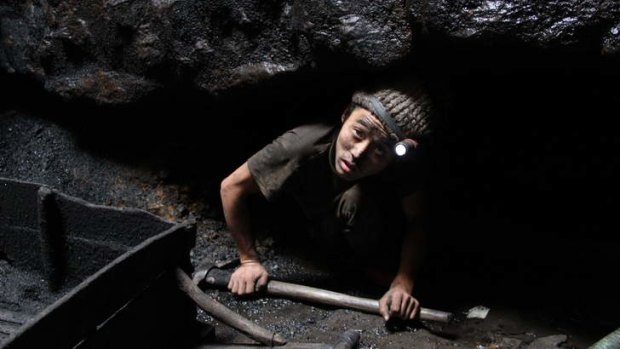Gilla Rai, 15, emerges from the rat-hole where he has been mining coal, in Meghalaya in north-east India.